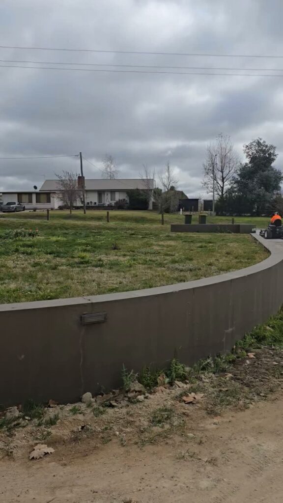 Freshly mown lawn above a rendered retaining wall