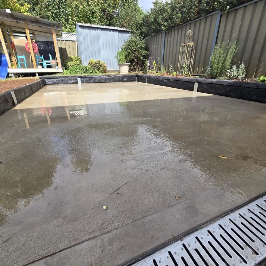 Freshly poured concrete slab in a backyard